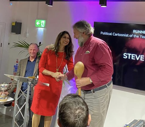 Former Guardian cartoonist Steve Bell receiving the Strube spoon (runner-up political cartoonist of the year) from Suella Braverman at the Political Cartoon Awards on 5 December 2023. 